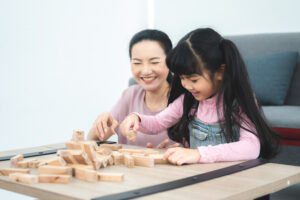 children development education, mother and daughter family playing and learning fun at home, young woman and eltern teacher are happy smiling together, little cute girl childhood concept